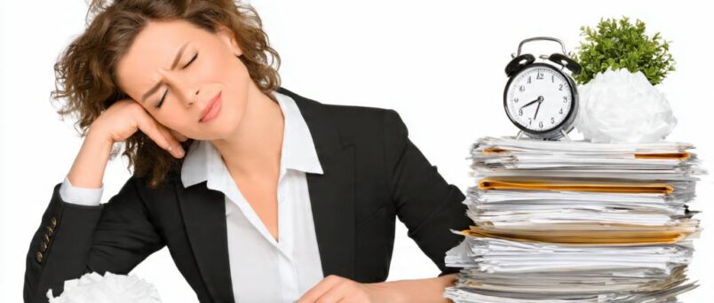 Person slumping at cluttered desk with phone notifications, looking overwhelmed by daily stress triggers.